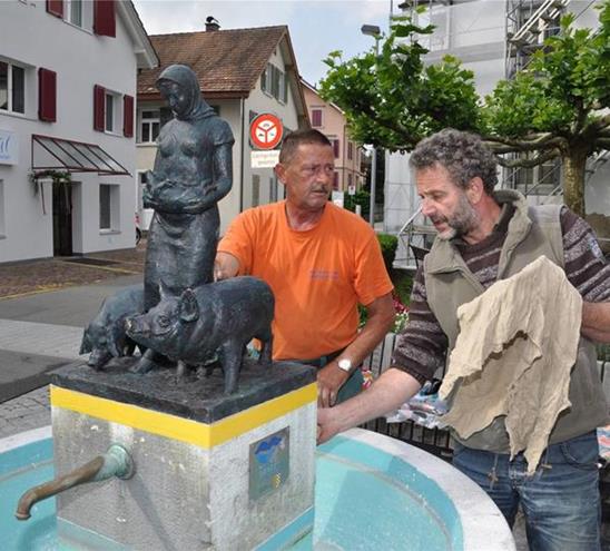 Assistiert von Regiebetrieb-Mitarbeiter Walter Muheim befestigt Angelo Steccanella die Bronze-Figur auf dem Brunnensockel. (Bild Werner Schneiter)